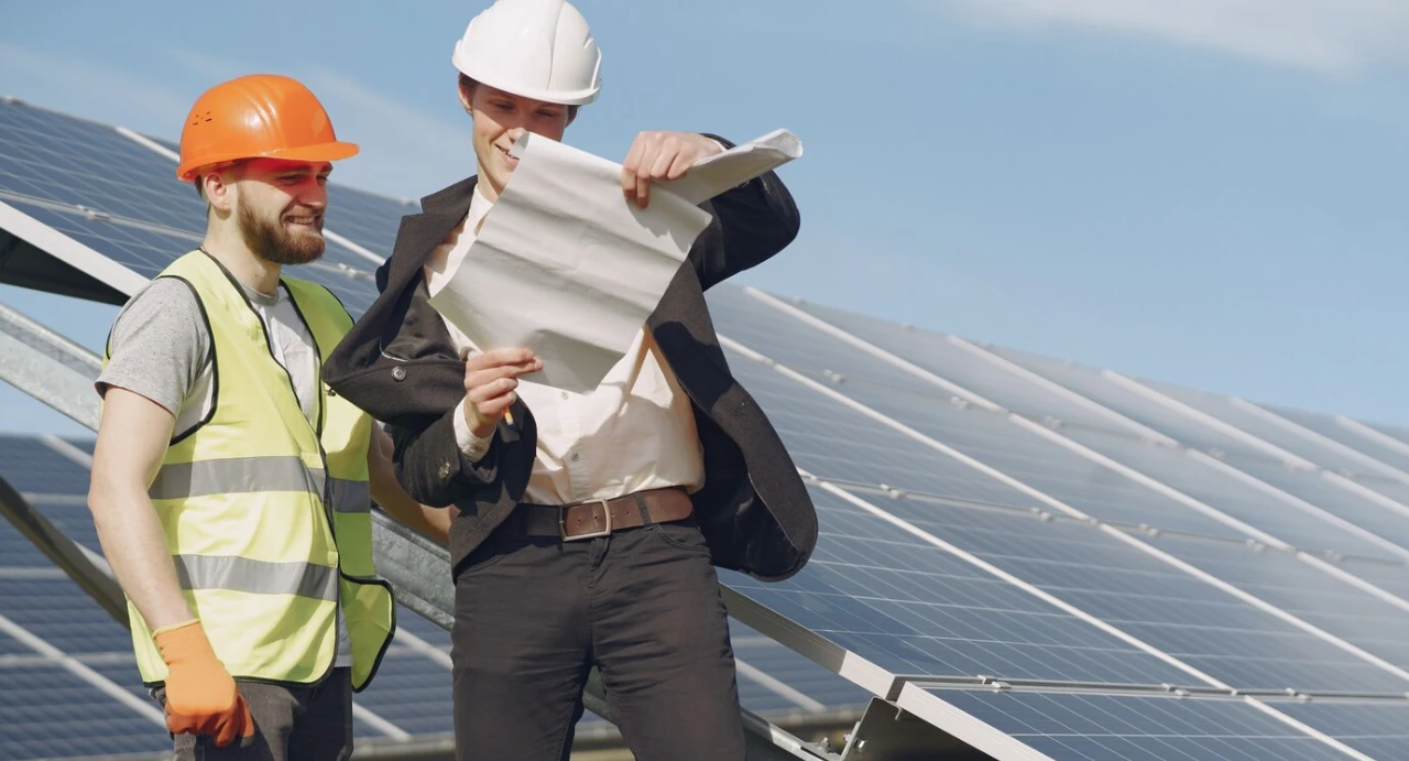 Un operaio tecnico e un dirigente pianificano i prossimi lavori sui panelli fotovoltaici.